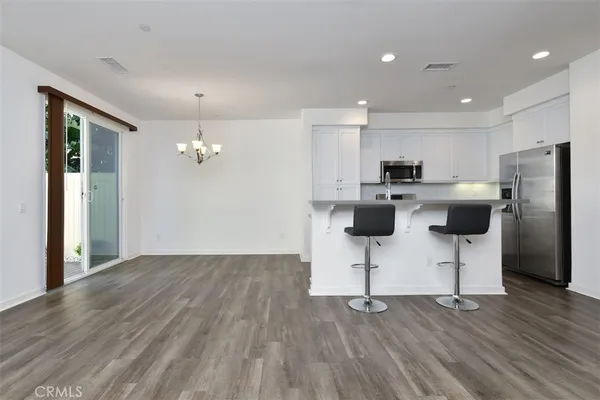 a view of kitchen with refrigerator microwave and wooden floor