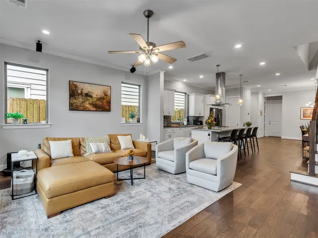 a living room with furniture kitchen view and a chandelier