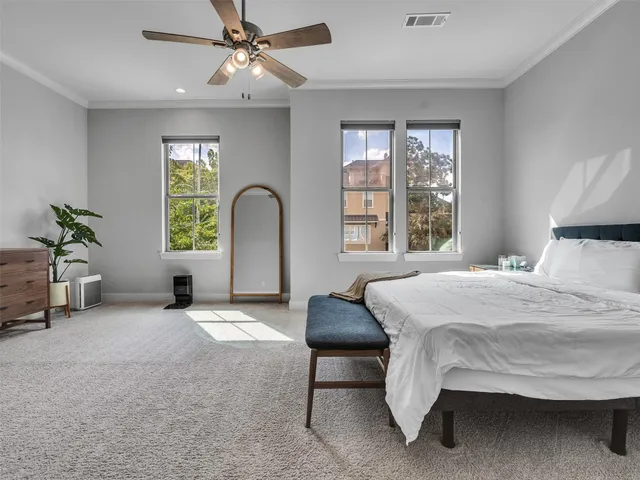 a bedroom with a bed a chandelier and a large window