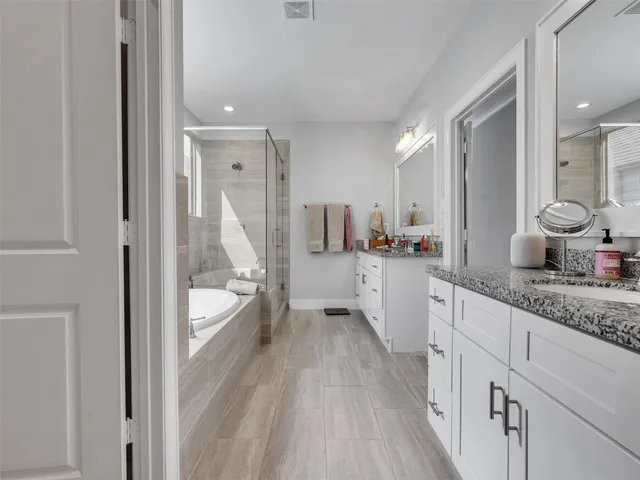 a large bathroom with a granite countertop sink mirror and a bathtub
