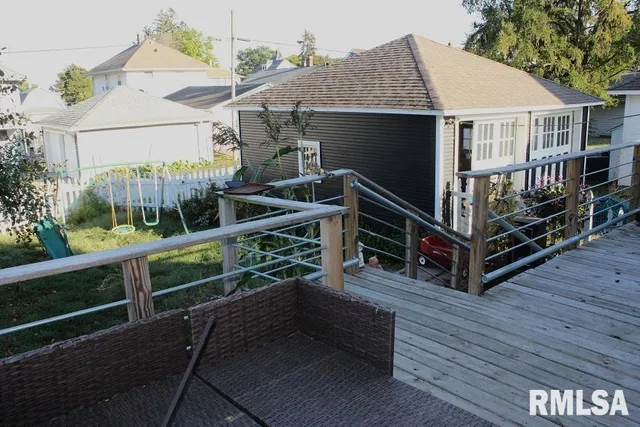 a view of house with a deck and a yard