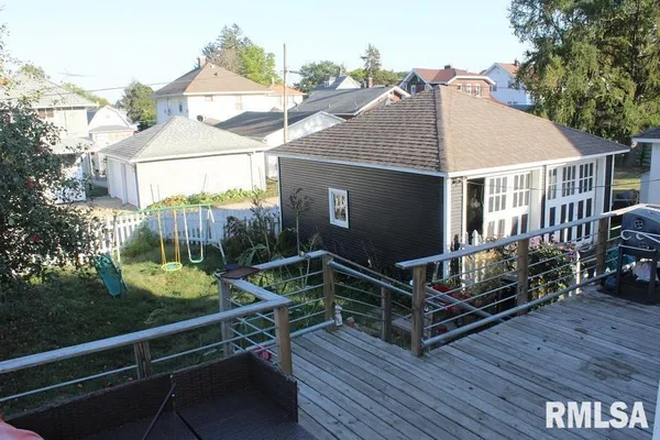 a view of a house with wooden deck and furniture