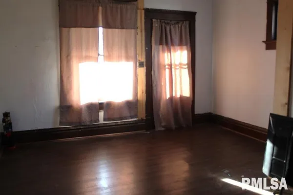a view of a room with wooden floor and a window