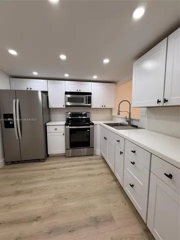 a kitchen with stainless steel appliances granite countertop a sink and a refrigerator