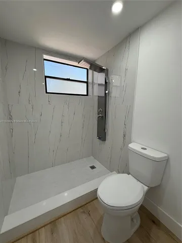a bathroom with a toilet and a shower
