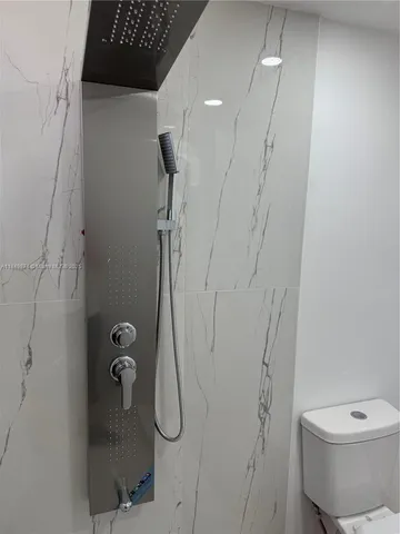 a bathroom with a toilet and a shower