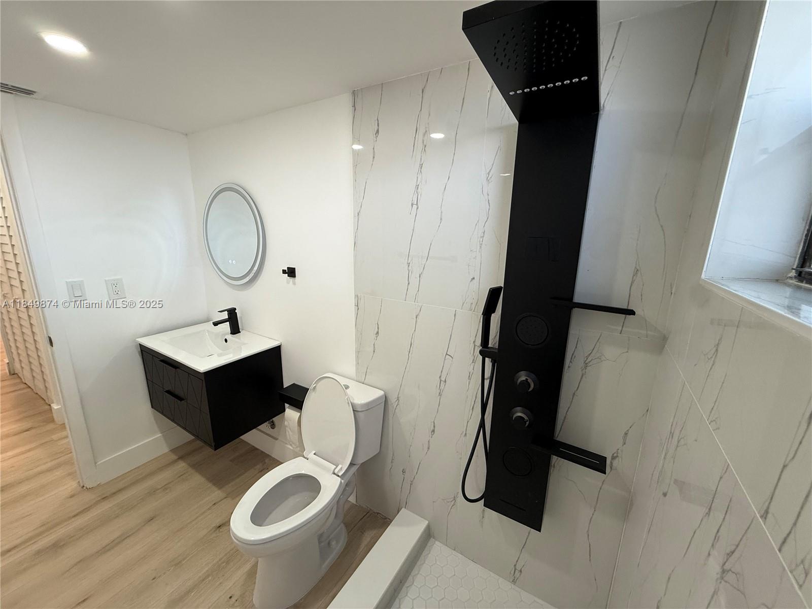 7950 West McNab Road, Unit 102 Tamarac, FL 33321 - Photo 22 of 34 a bathroom with a toilet sink and mirror