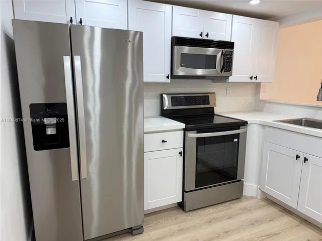 a kitchen with stainless steel appliances a refrigerator microwave and sink