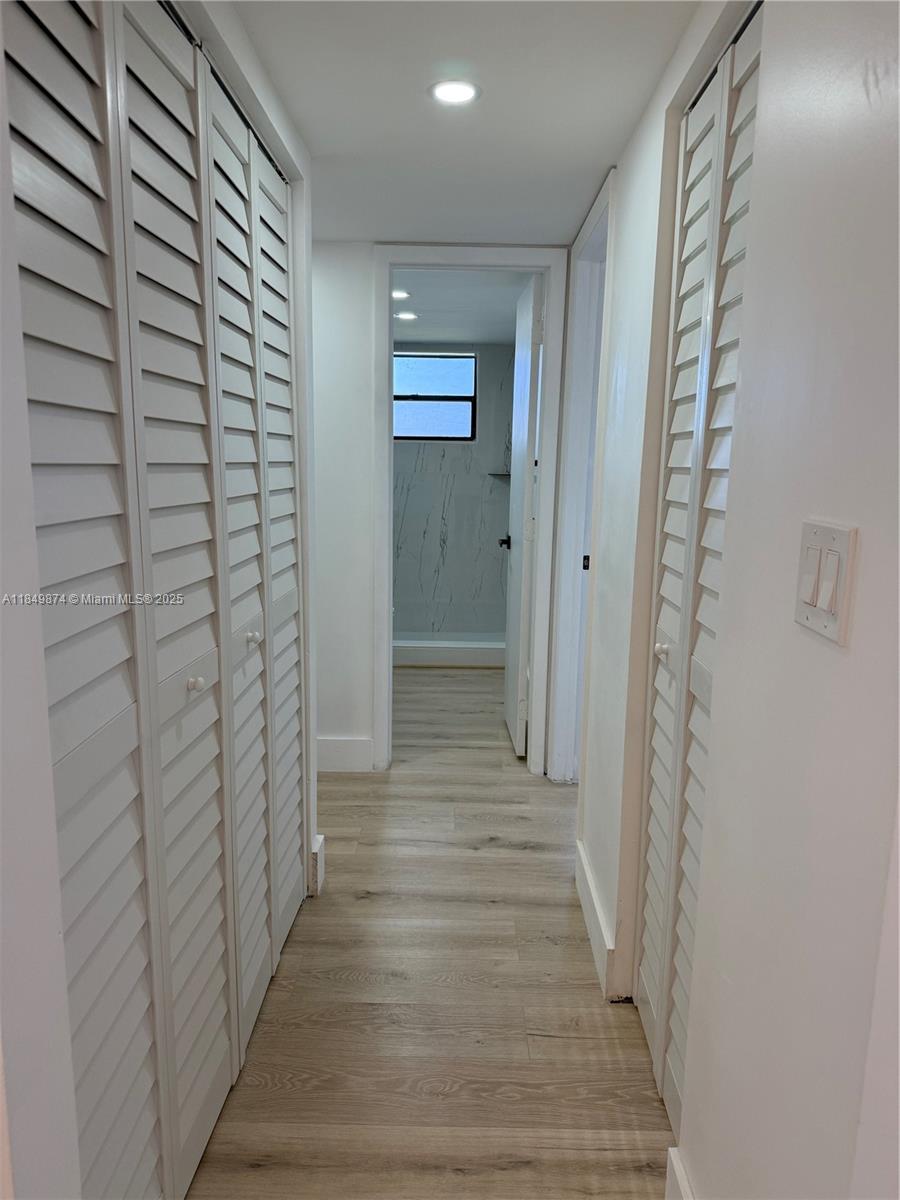 7950 West McNab Road, Unit 102 Tamarac, FL 33321 - Photo 10 of 34 a view of a hallway with wooden floor and staircase