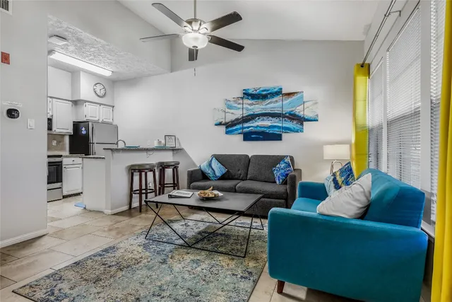a living room with furniture and a kitchen