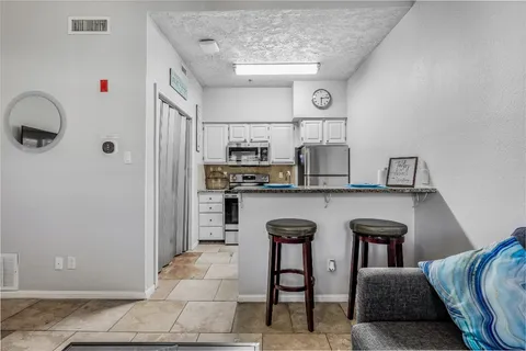 a living room with granite countertop furniture a rug and a chandelier