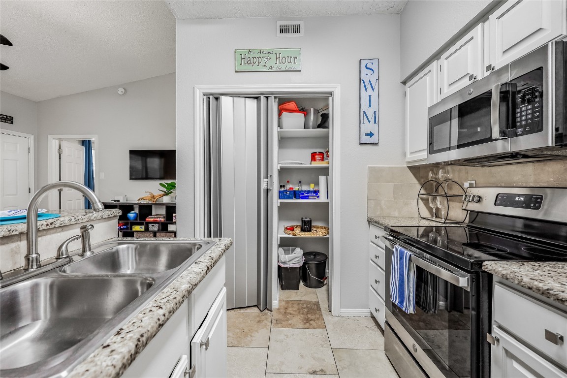 3404 American Drive, Unit 3300 Lago Vista, TX 78645 - Photo 5 of 39 a kitchen with stainless steel appliances granite countertop a sink and a microwave