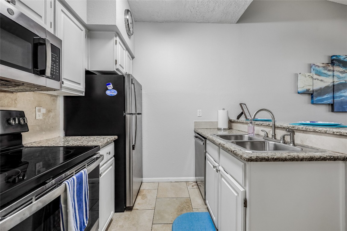 3404 American Drive, Unit 3300 Lago Vista, TX 78645 - Photo 6 of 39 a kitchen with stainless steel appliances granite countertop a sink stove and refrigerator