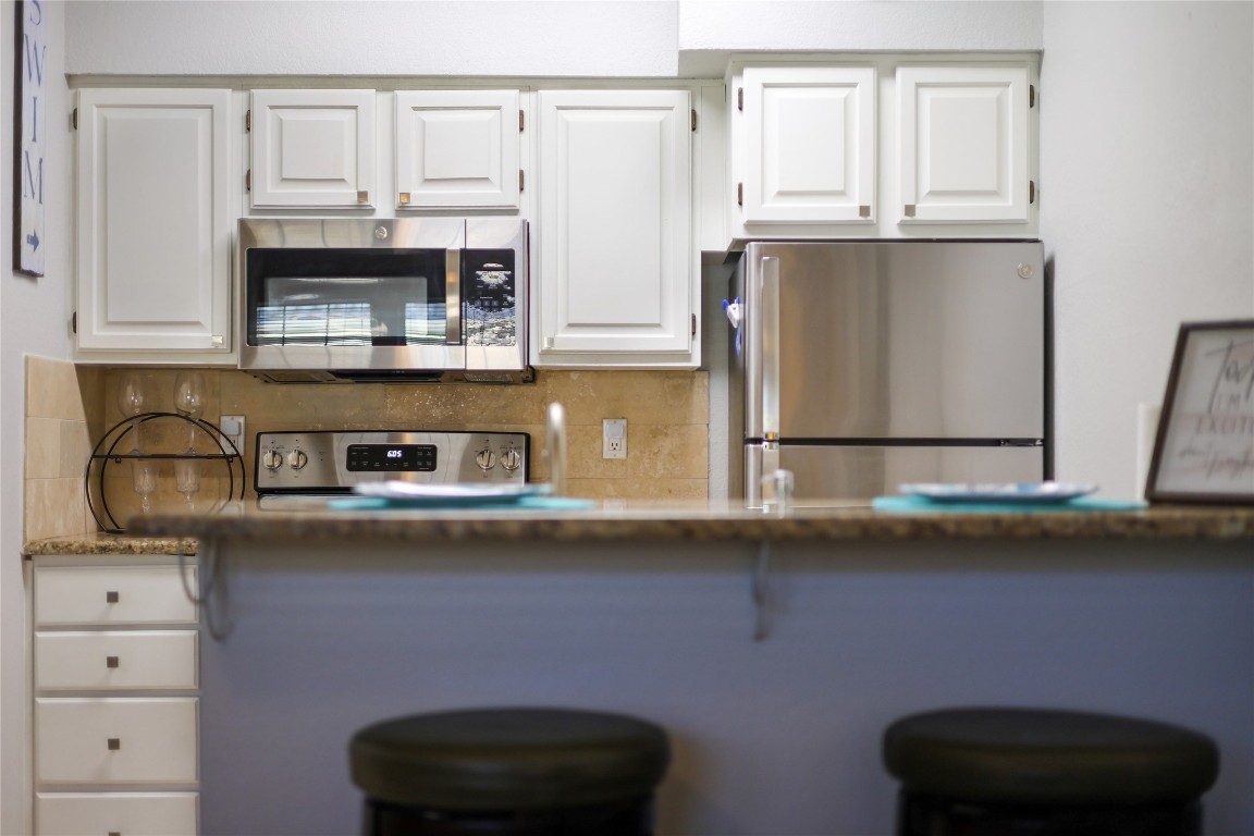 3404 American Drive, Unit 3300 Lago Vista, TX 78645 - Photo 7 of 39 a kitchen with stainless steel appliances granite countertop a sink a stove and cabinets