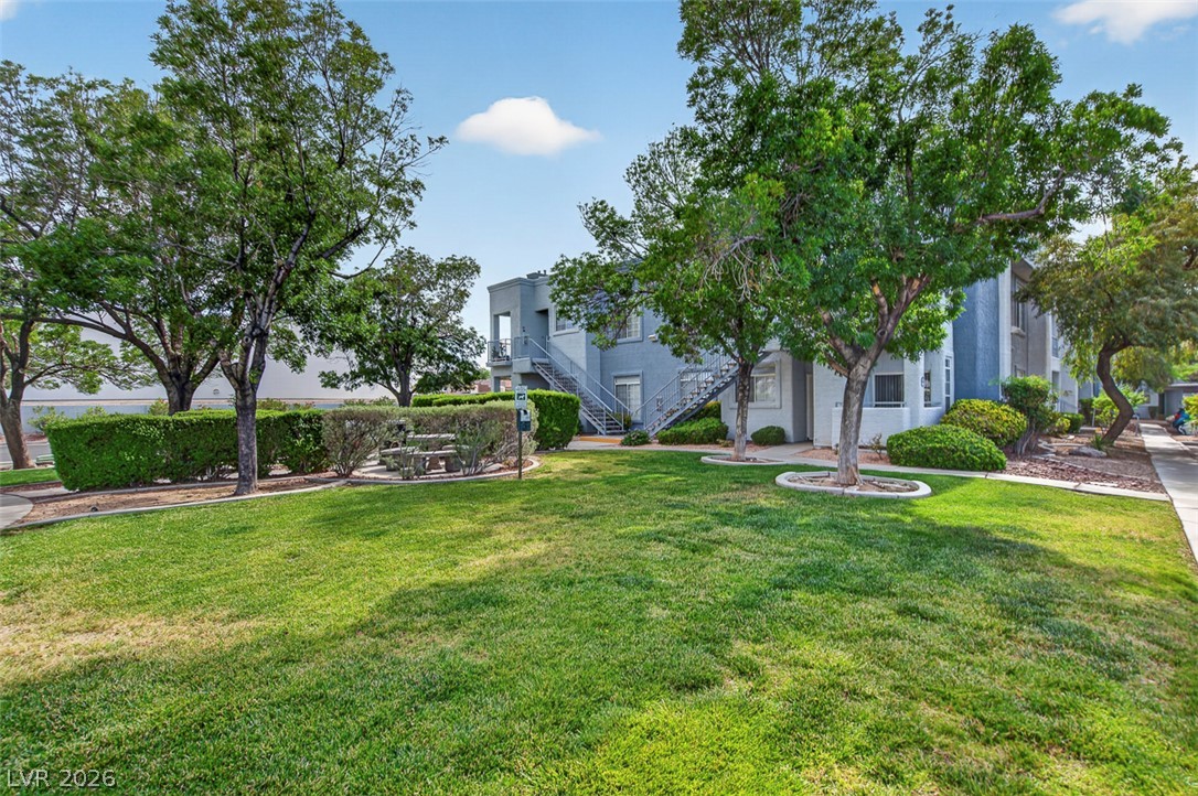 2201 Ramsgate Drive, Unit 1011 Henderson, NV 89074 - Photo 32 of 40 Manicured green spaces and mature trees surround this residential building, offering a serene community environment.