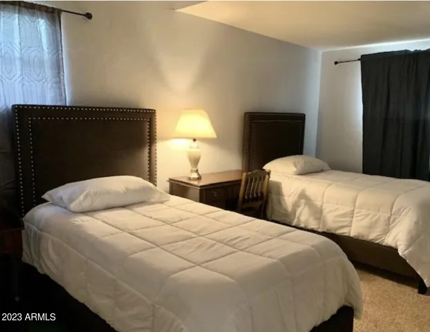 a bedroom with two bed and a night stand