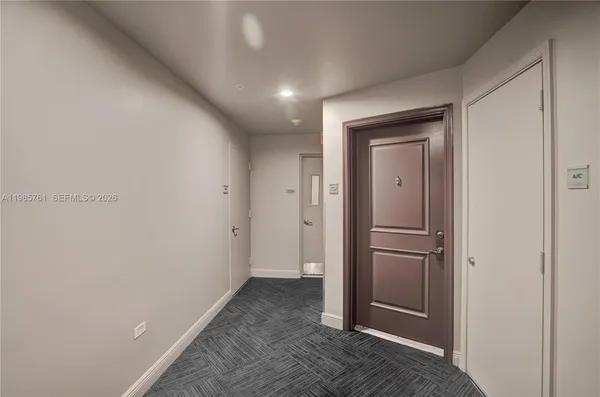 a view of a hallway with wooden floor and closet area