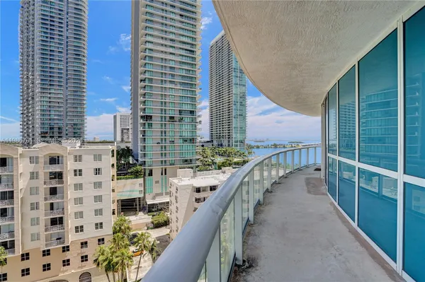 a living room with furniture potted plant and large windows