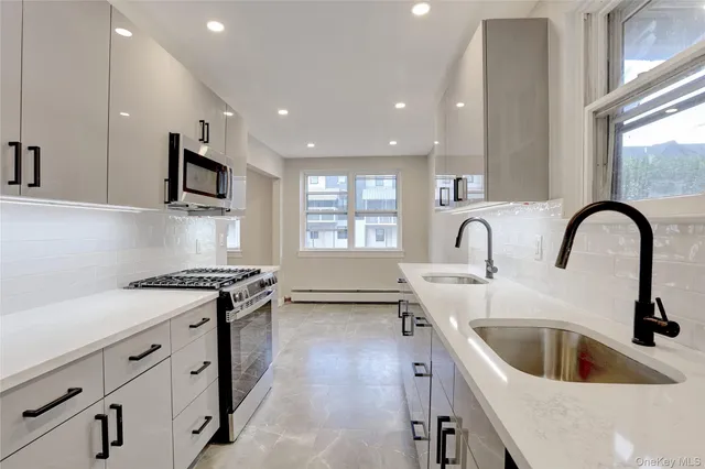 a kitchen with stainless steel appliances granite countertop a sink a stove and a refrigerator