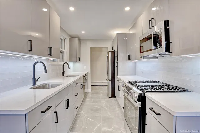 a kitchen with stainless steel appliances granite countertop a sink stove and refrigerator
