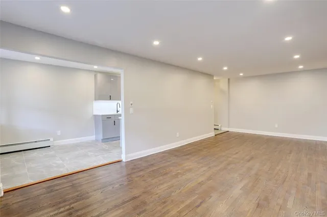 an empty room with wooden floor and entrance
