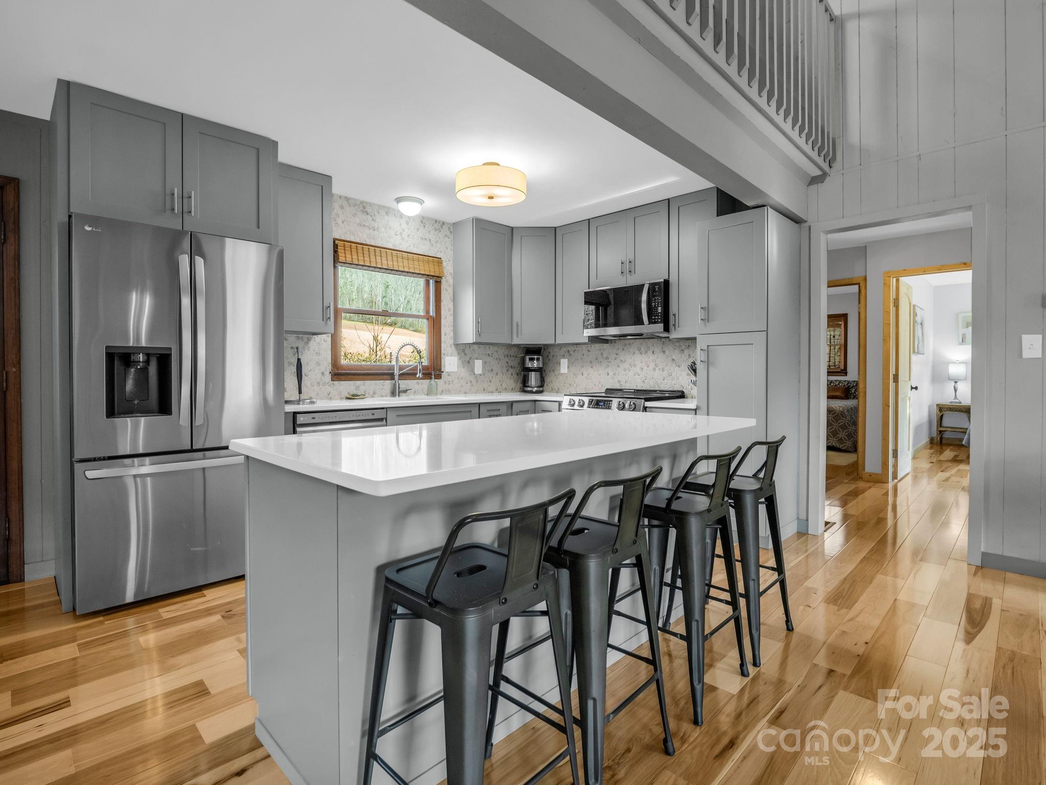 132 Hurd Road Canton, NC 28716 - Photo 24 of 46 a kitchen with stainless steel appliances granite countertop a refrigerator a sink a stove a microwave and a dining table with wooden floor