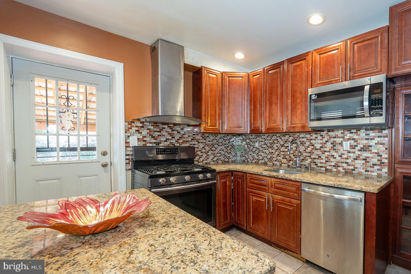 136 Summit Avenue Upper Darby, PA 19082 - Photo 15 of 48 a kitchen with stainless steel appliances kitchen island granite countertop a stove sink and microwave