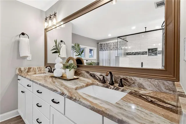a bathroom with a sink vanity and mirror