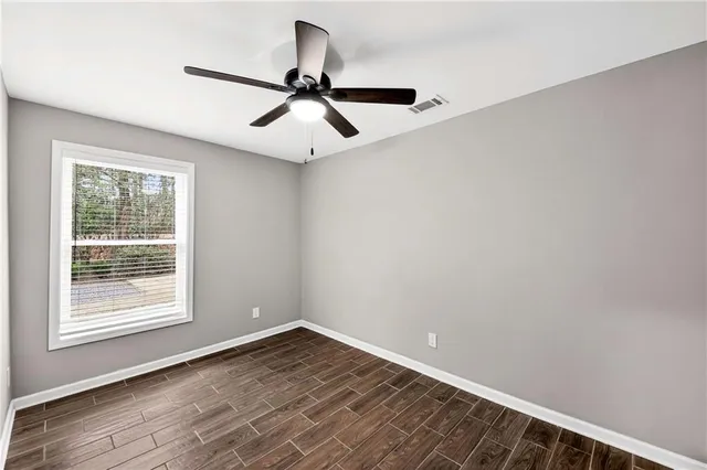 a view of backyard with large trees and wooden fence