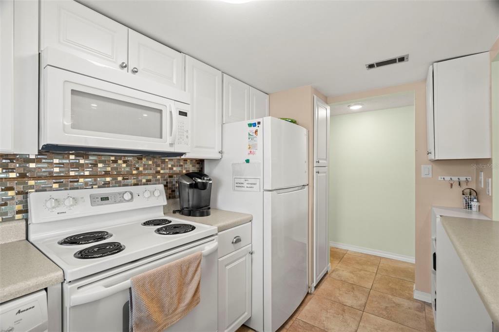 7701 Starkey Road, Unit 601 Seminole, FL 33777 - Photo 11 of 28 a kitchen with a refrigerator a stove a sink and cabinets