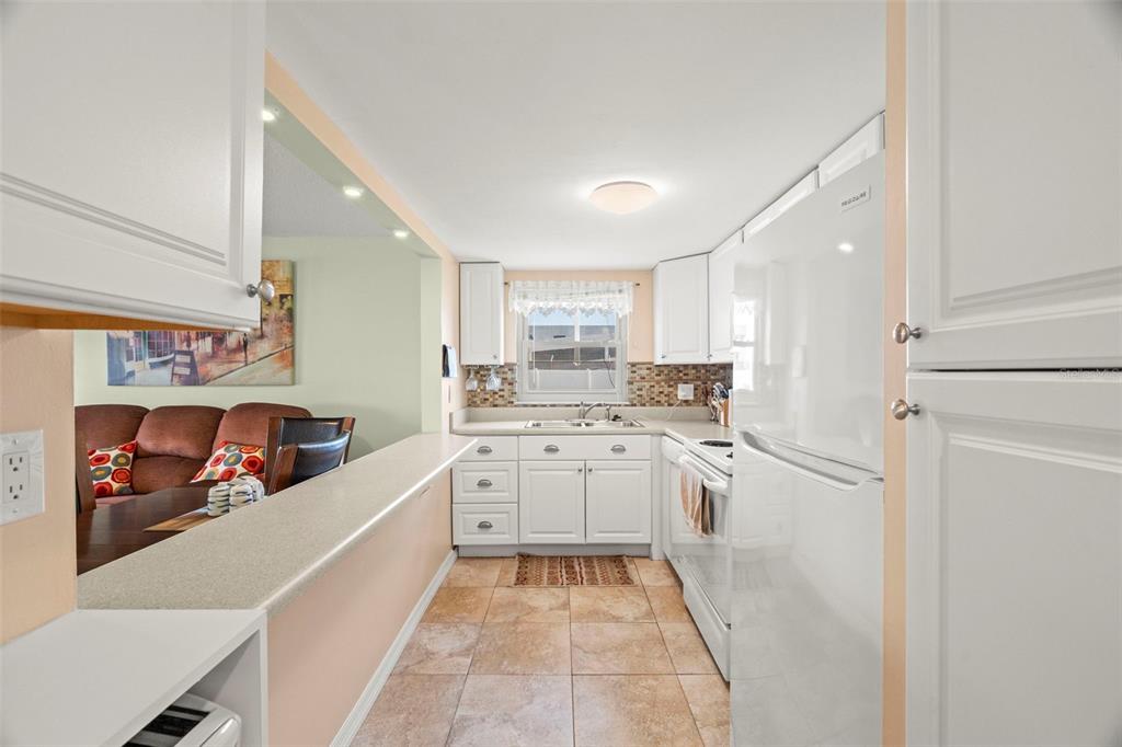 7701 Starkey Road, Unit 601 Seminole, FL 33777 - Photo 10 of 28 a kitchen with stainless steel appliances granite countertop a refrigerator and a sink