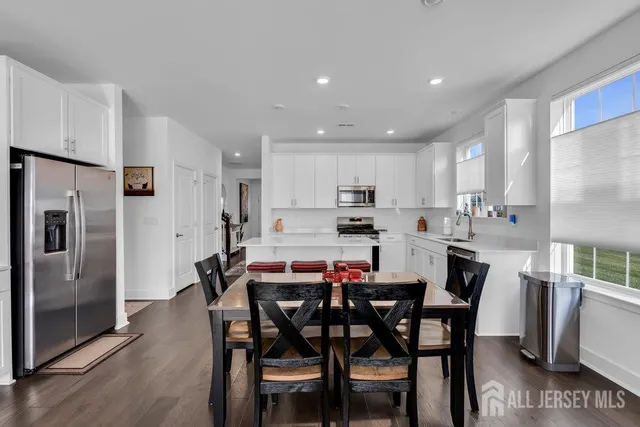 a kitchen with kitchen island a refrigerator and wooden floor
