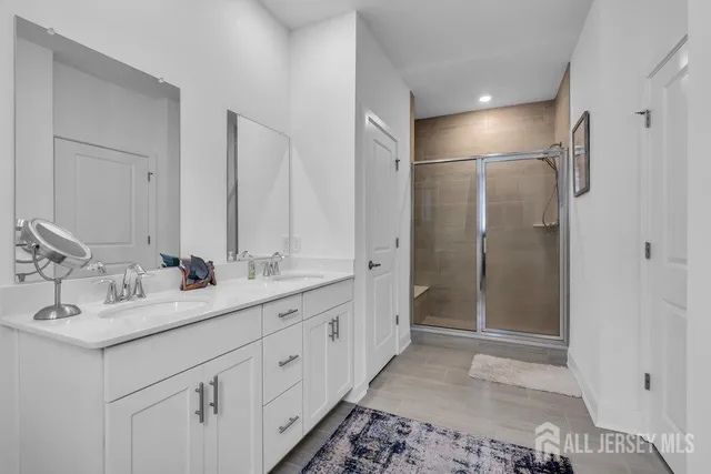 a bathroom with a double vanity sink mirror and shower