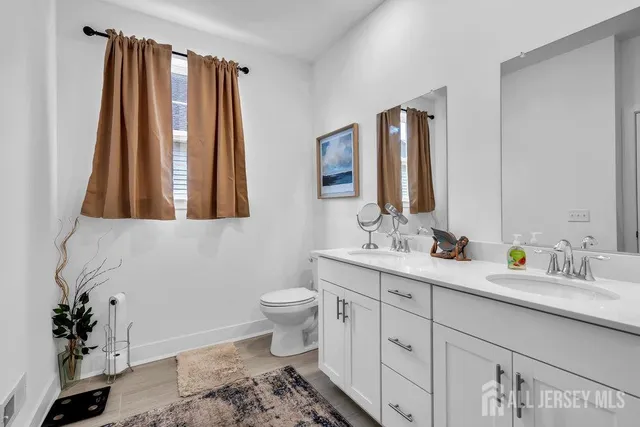 a bathroom with a toilet sink and mirror