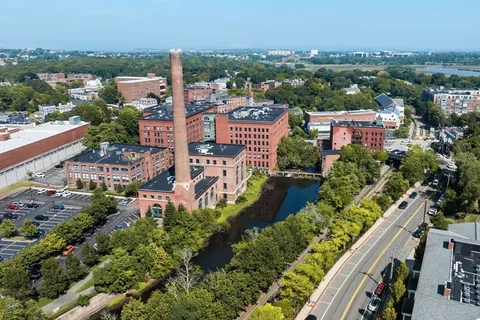 an aerial view of residential houses with outdoor space and river view