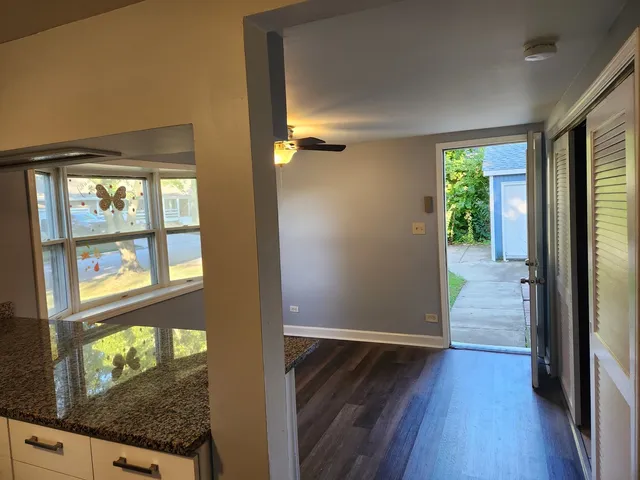 a view of a hallway with wooden floor and a living room