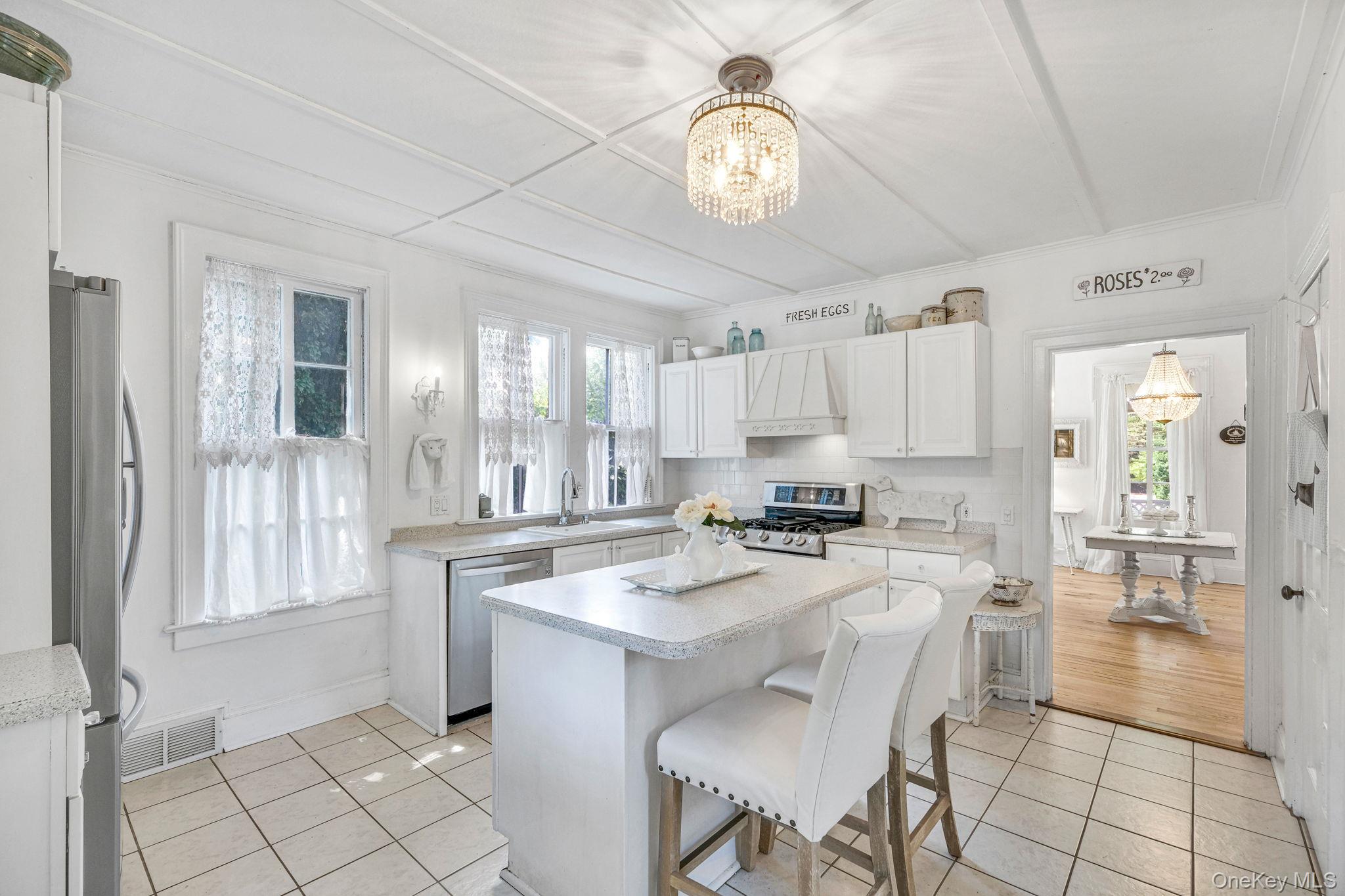 45 Shore Road East Setauket, NY 11733 - Photo 14 of 27 a kitchen with a dining table chairs and white cabinets