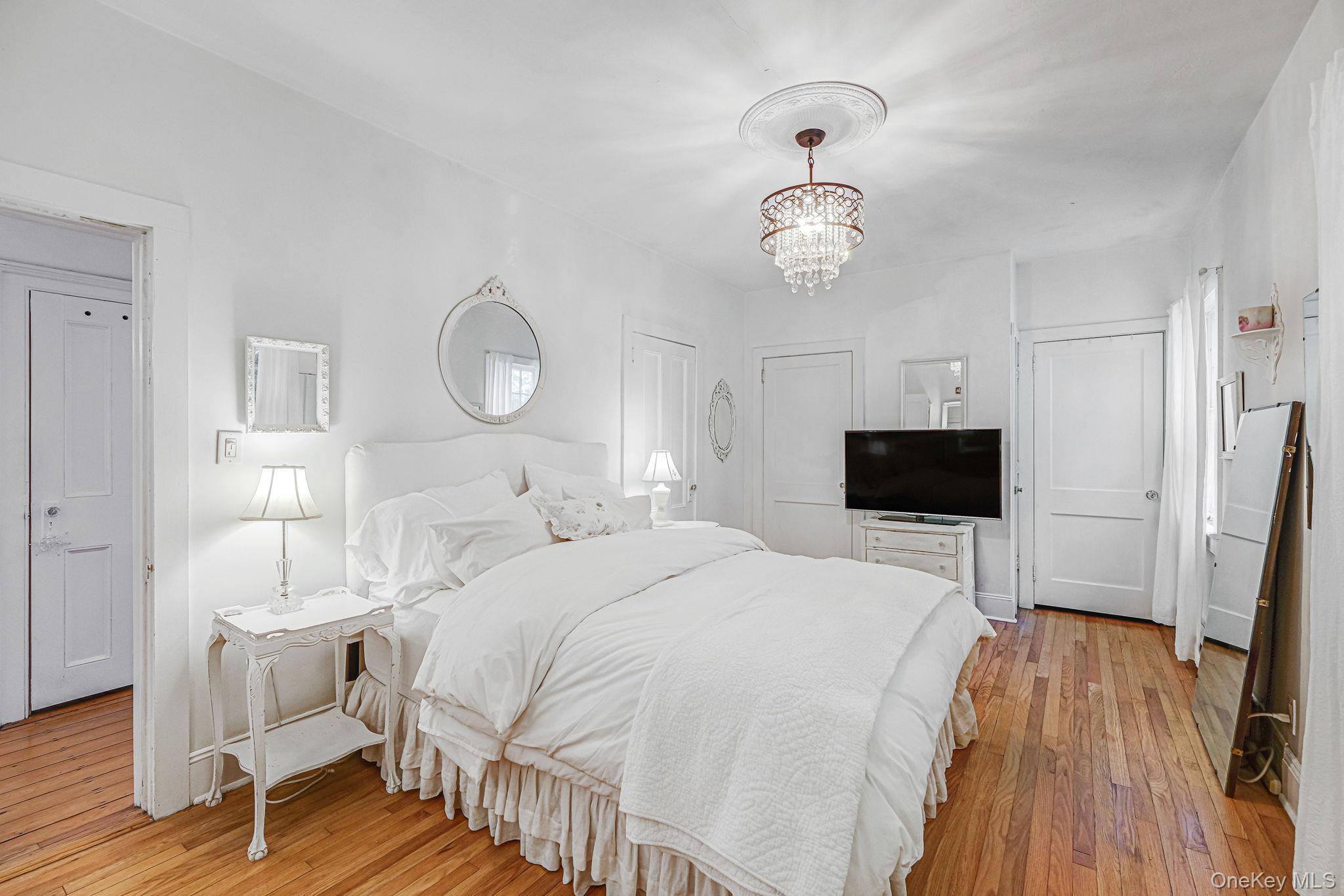 45 Shore Road East Setauket, NY 11733 - Photo 15 of 27 a spacious bedroom with a bed and a flat screen tv