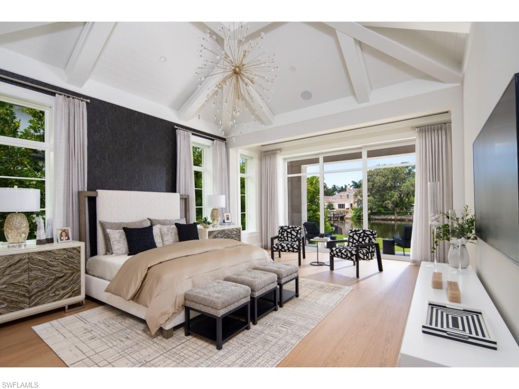 3200 Gin Lane Naples, FL 34102 - Photo 9 of 20 a bedroom with a bed a large window and a flat tv screen