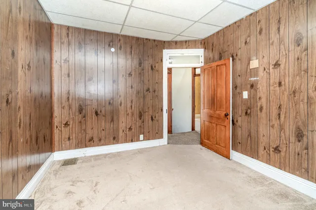 a view of a hallway with wooden walls