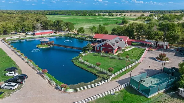 an aerial view of a house with pool big yard and large tree