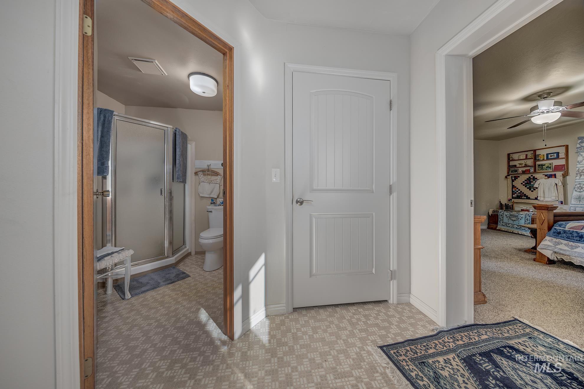 1365 Highway 95 Weiser, ID 83672 - Photo 13 of 34 Full bathroom with connected bathroom, a shower stall, light carpet, and a ceiling fan