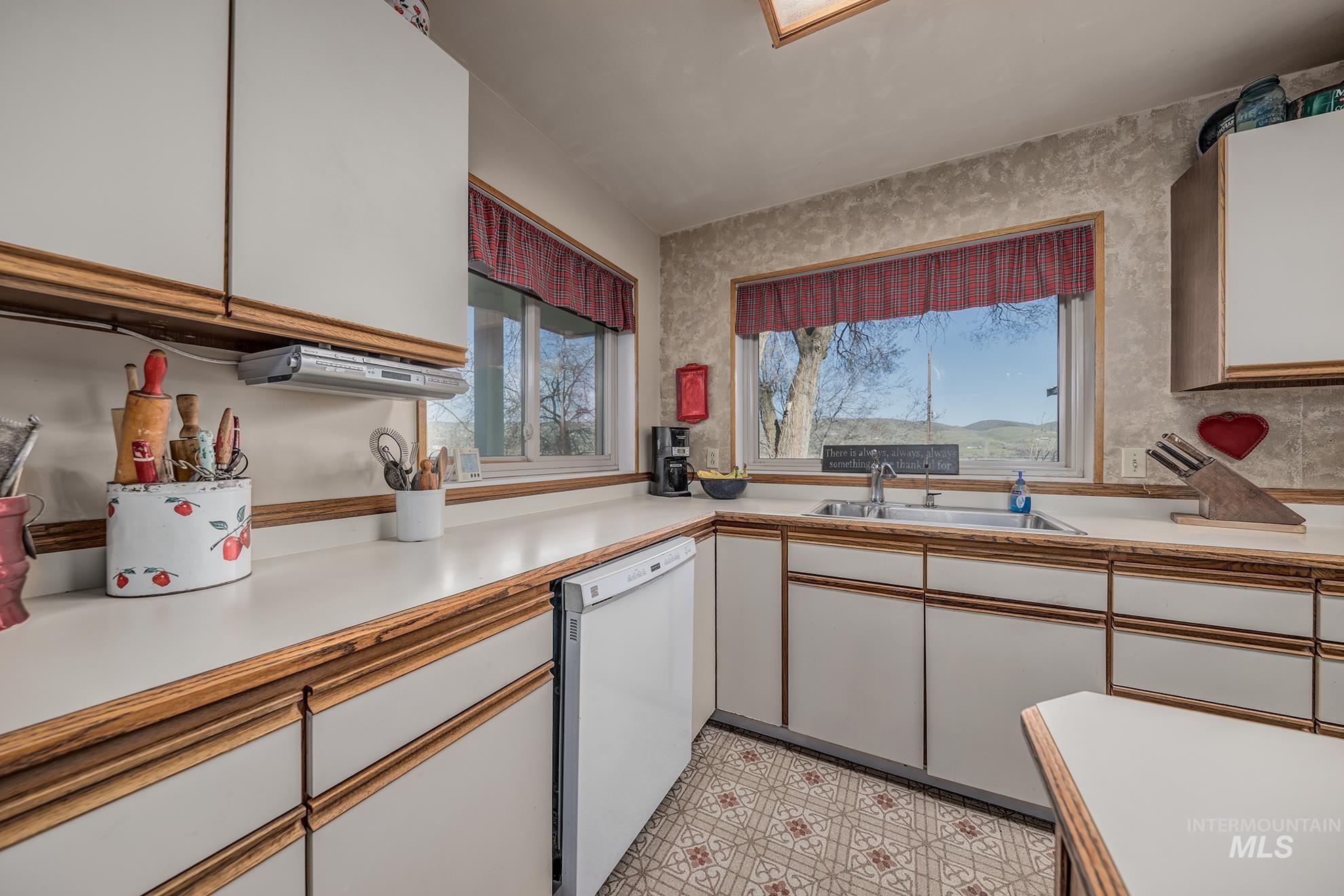 1365 Highway 95 Weiser, ID 83672 - Photo 4 of 34 Kitchen with two tone cabinetry, light countertops, white dishwasher, and light floors