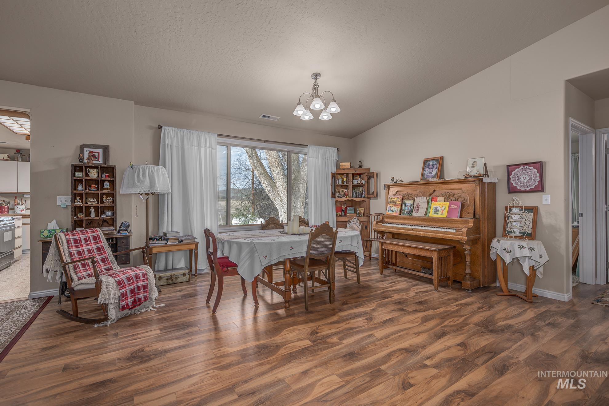 1365 Highway 95 Weiser, ID 83672 - Photo 8 of 34 Dining room with dark wood-type flooring, lofted ceiling, and a chandelier