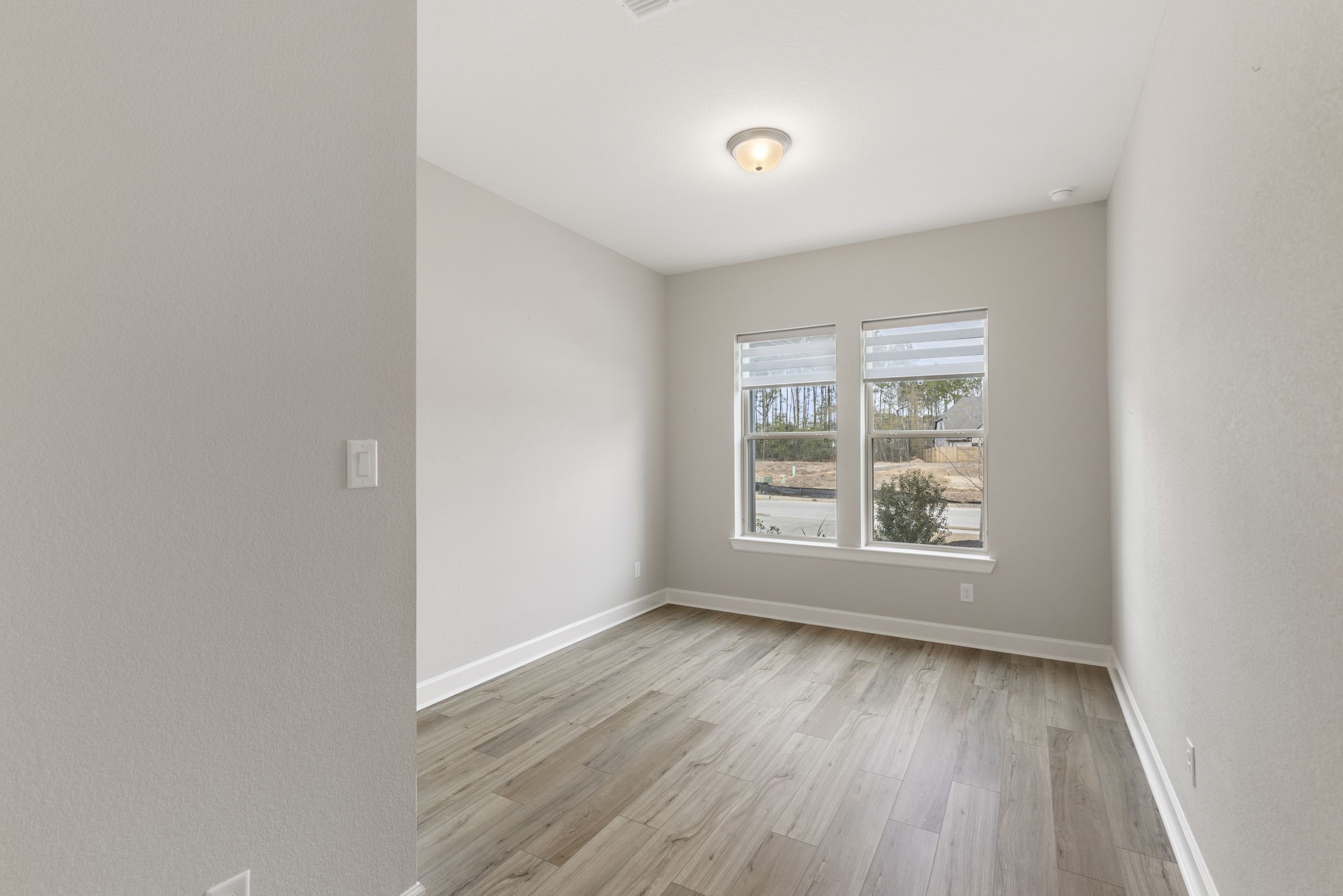 15834 Moran Meadow Street Conroe, TX 77302 - Photo 25 of 41 an empty room with wooden floor and windows