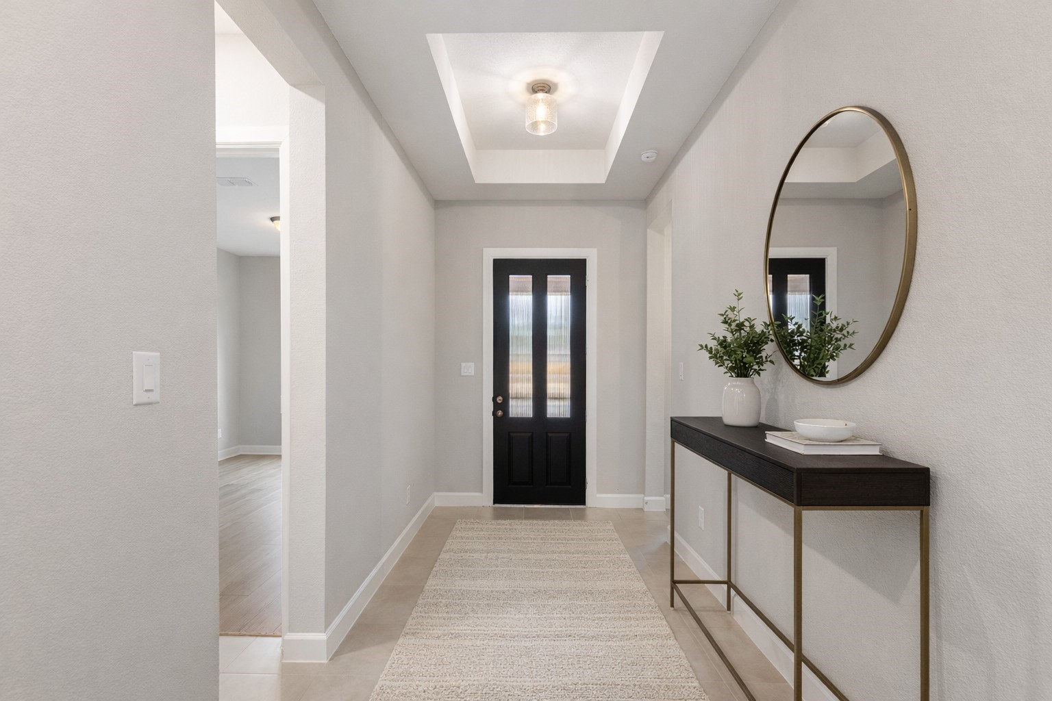 15834 Moran Meadow Street Conroe, TX 77302 - Photo 3 of 41 a view of a hallway with wooden floor and a mirror