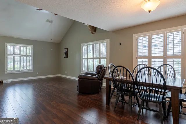 a view of a a dining room with furniture window and wooden floor