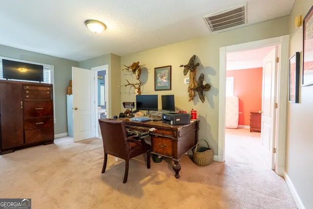 a view of a workspace with furniture and a window