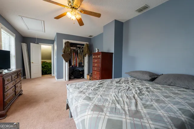 a bedroom with a bed and a flat tv screen on dresser