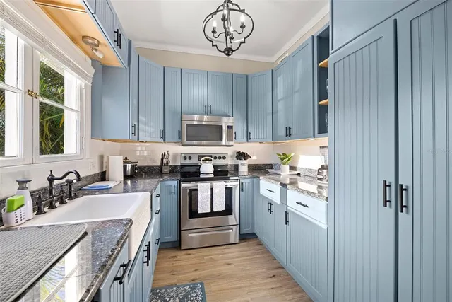 a kitchen with kitchen island granite countertop a stove top oven a sink and dishwasher